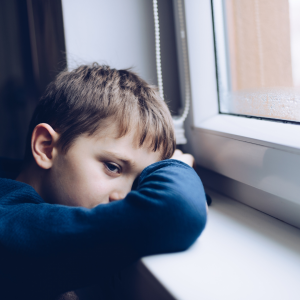 kid leaning against a window sill